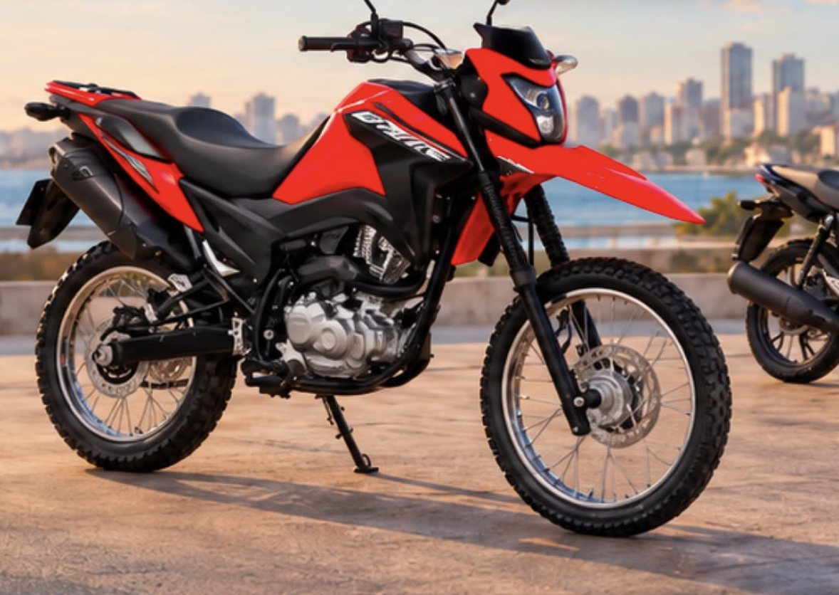 Honda Bros 160 vermelha estacionada na orla, com prédios ao fundo